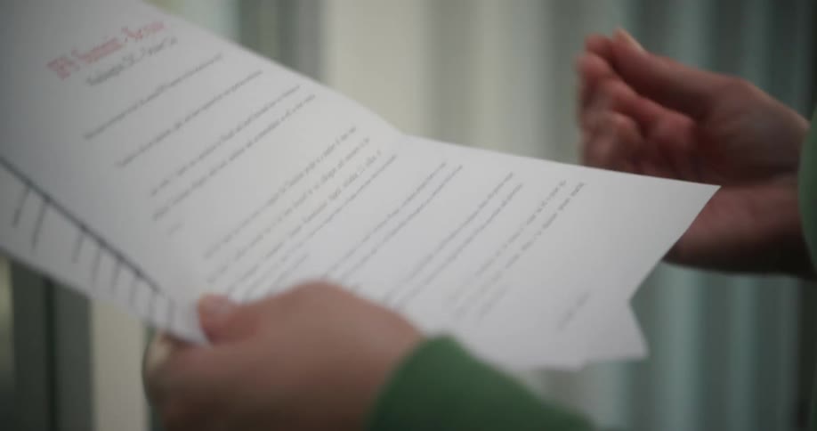 Womans hands holding papers while she rehearses