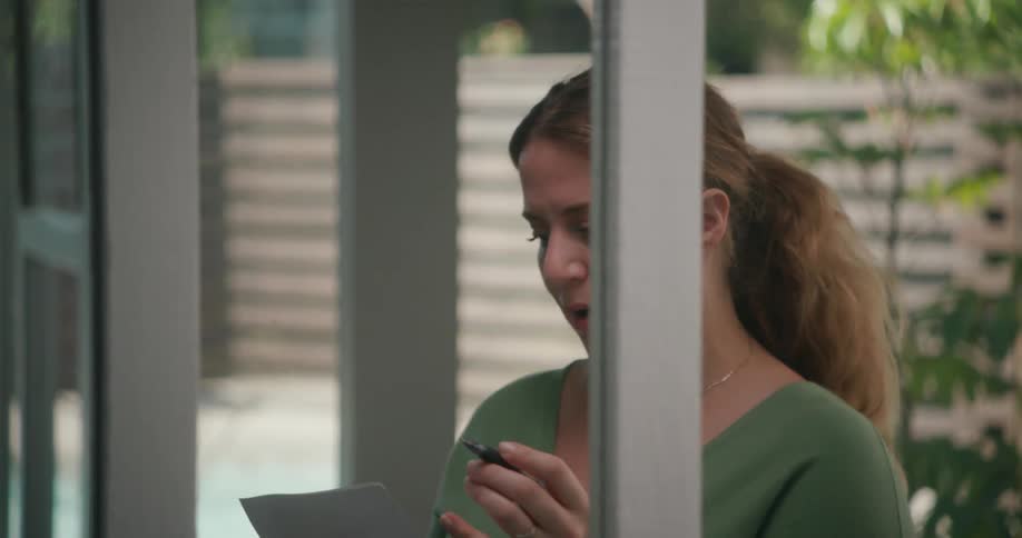 Woman practicing a speech or reading a script out loud practicing in front of a mirror at home