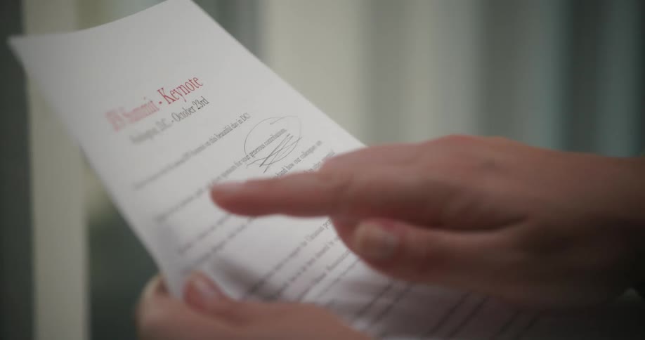 Close up of a person reading a document putting their finger under the letters while reading