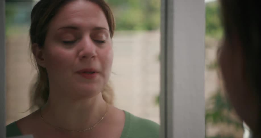 Woman reading a script or speech out loud in front of a mirror at home
