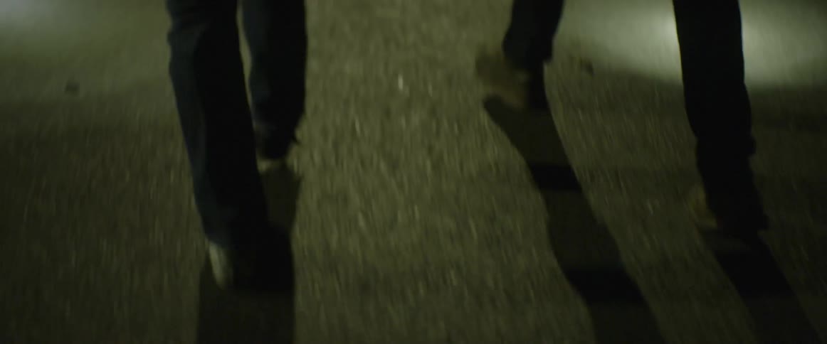 The feet and legs of people walking quickly at night