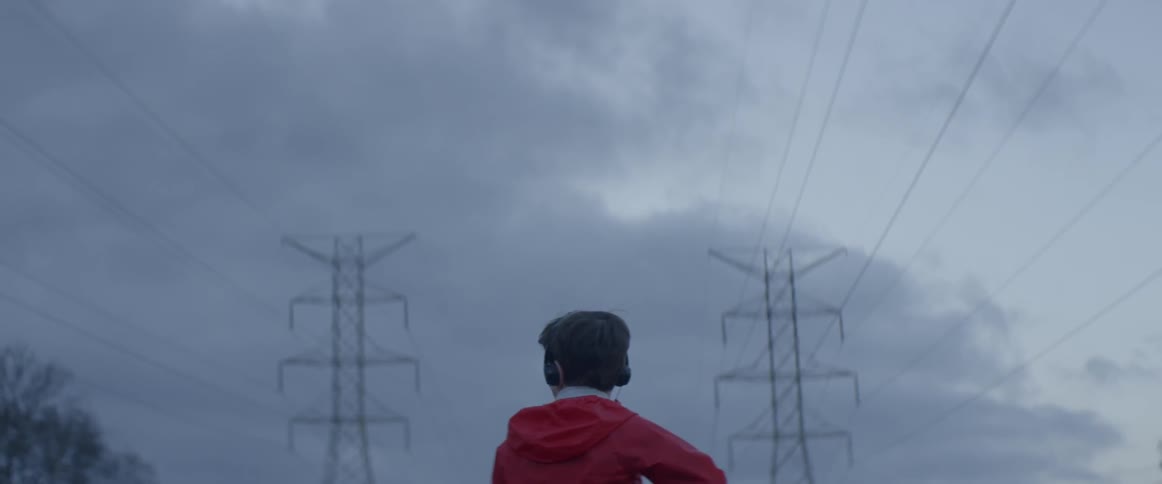 A man is wearing headphones on a cloudy day