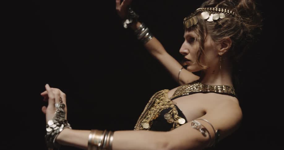 A woman rolls her arms and body while belly dancing