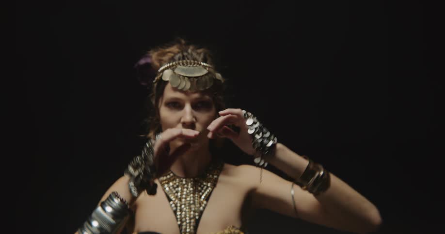 A belly dancer moves her arms in a wave motion