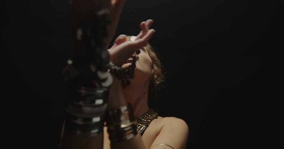 A woman is swaying her hands as she dances