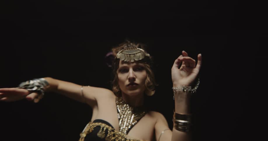 A belly dancer waves her arms up and down