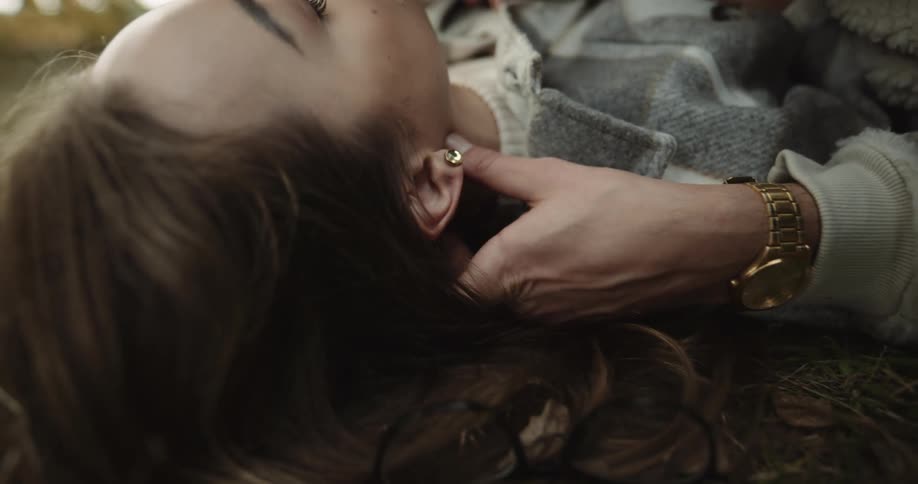 A young couple is laying down in the woods in the day time