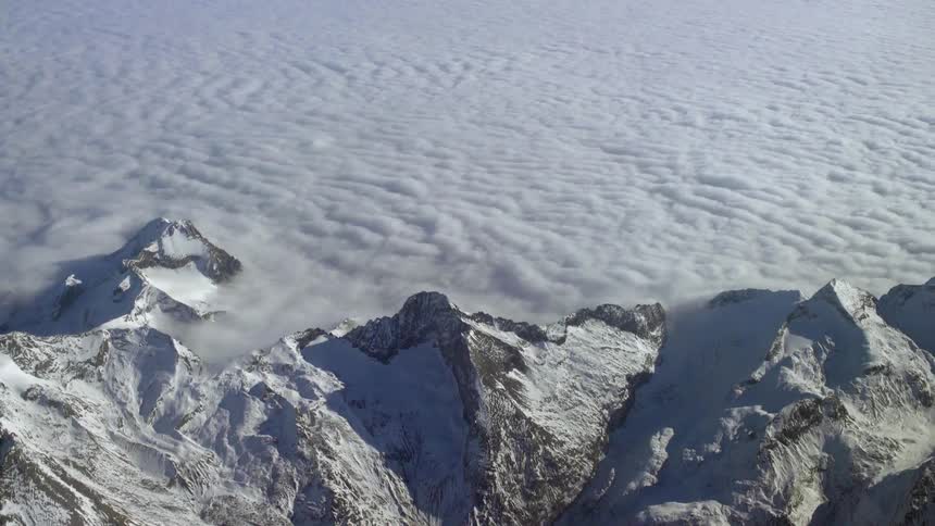 Thick clouds covering snowy mountains