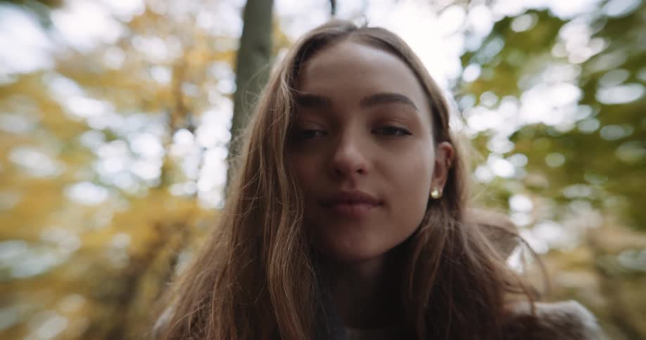 A woman smiles while posing in the forest
