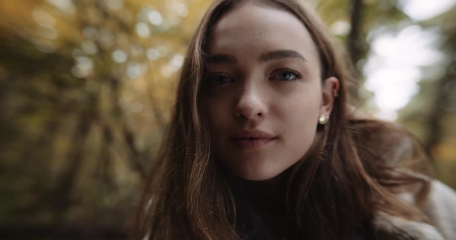 A woman is smiling in the forest