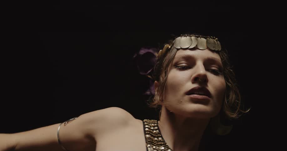 A woman moves her arms and shoulders in a seductive manner as she dances