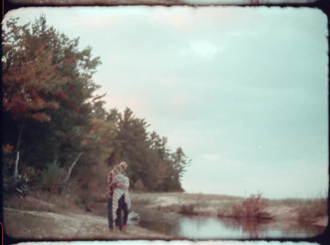 A man and woman walk together and kiss