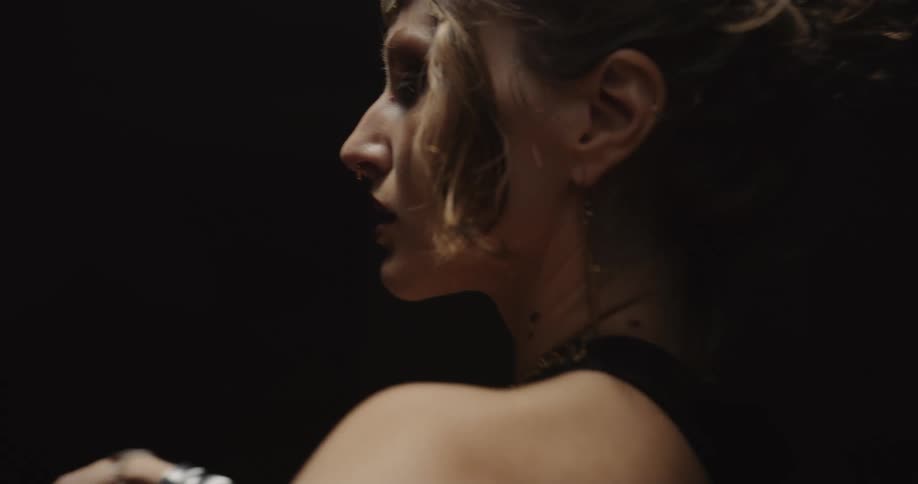 A belly dancer spins around in a dim room
