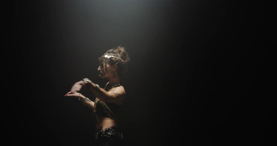 A belly dancer in ornate jewelry and beaded clothing