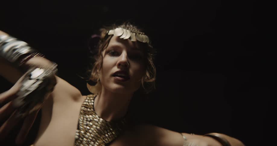 A woman dancing moving her arms and hands slowly wearing jewelry