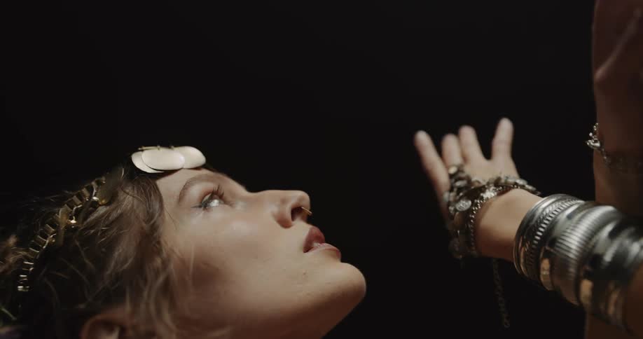 An up close of a woman looking up moving her hands and arms slowly