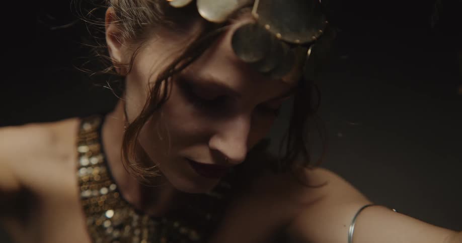 A woman slowly dancing and moving her arms around while wearing jewelry