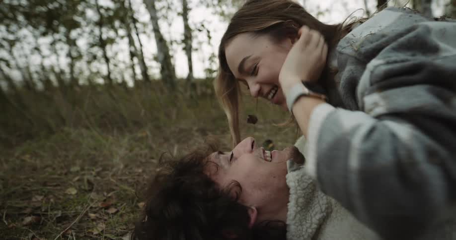 A couple kiss and hug on the ground
