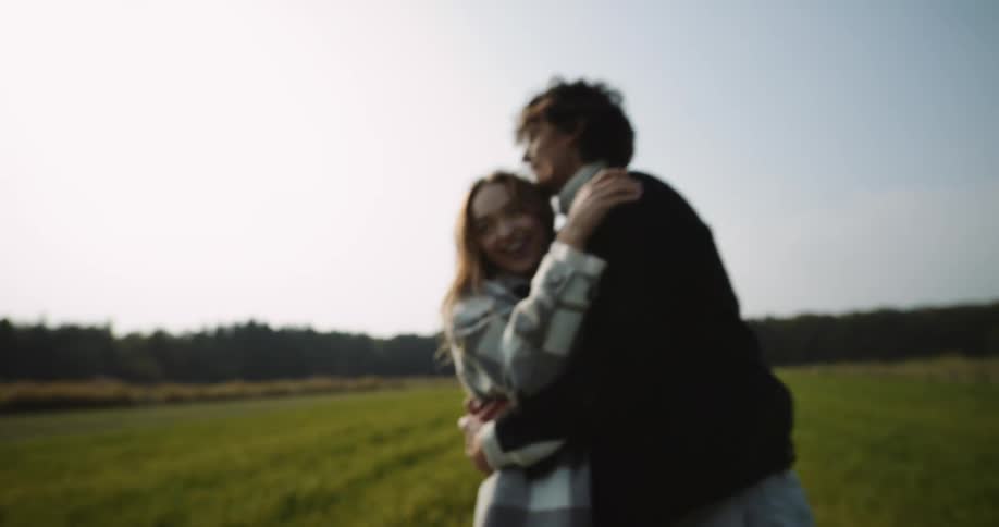 Two people that are dating are outdoors in a field