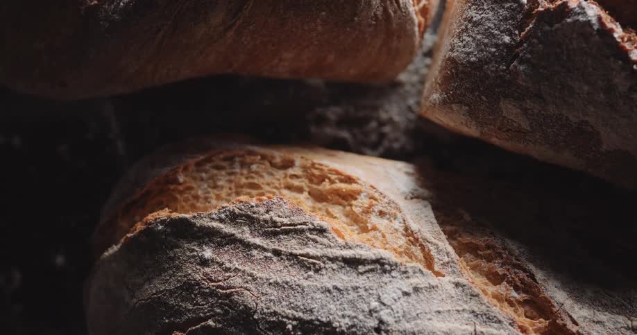 The split top of freshly baked bread loaves on a counter