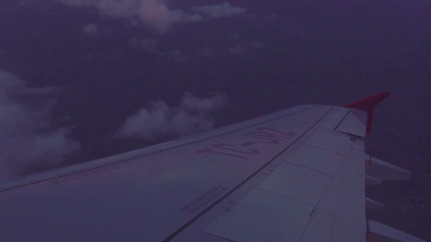 The wing of an airplane and the clouds below it while in flight