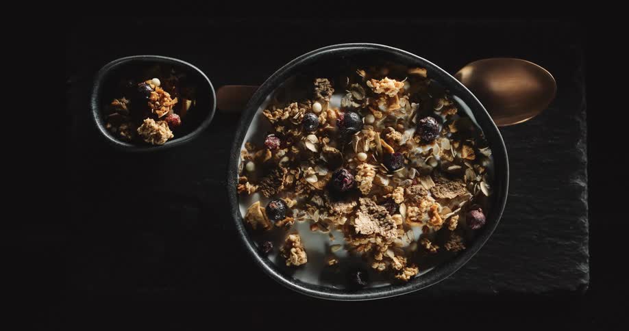 A bowl of oats and milk are on the table