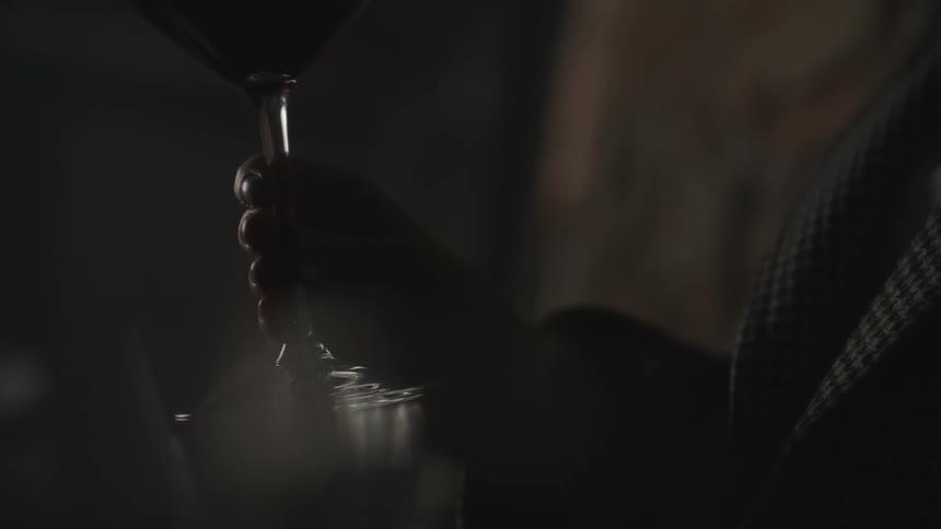 A person holding a glass of wine at night