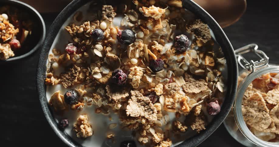 Display of granola cereal in a bowl with berries and milk