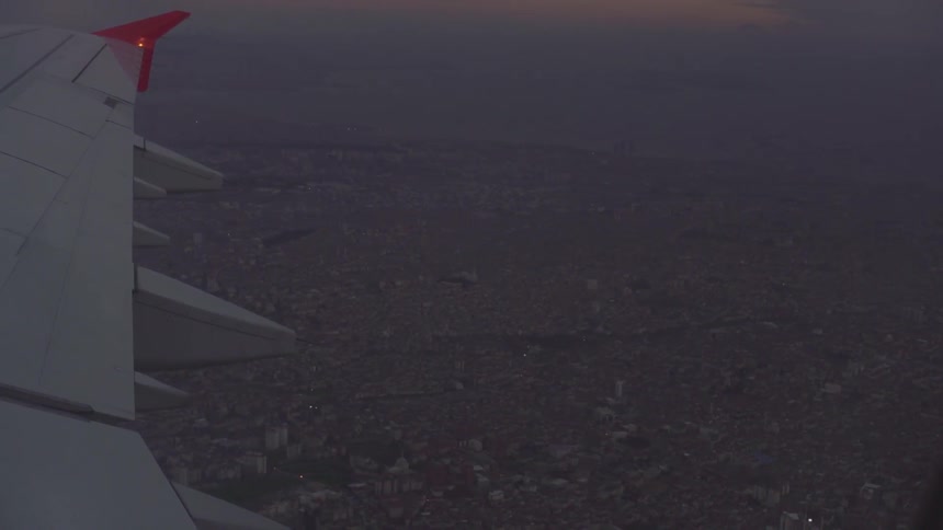 A plane flies over a city at night