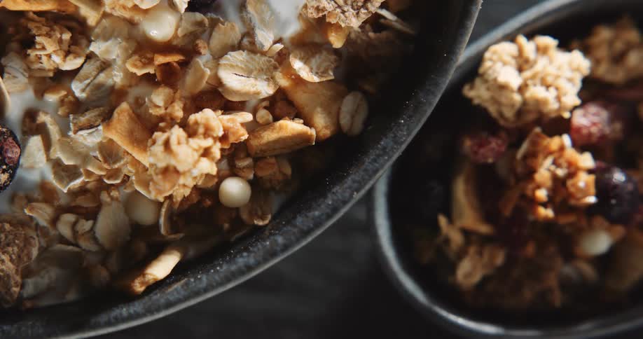 An up close view of granola and fruit in two separate containers
