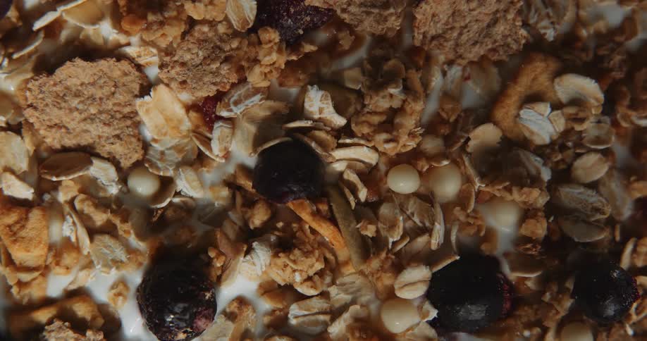 A close up of cereal is shown with flakes nuts oats and prunes in milk