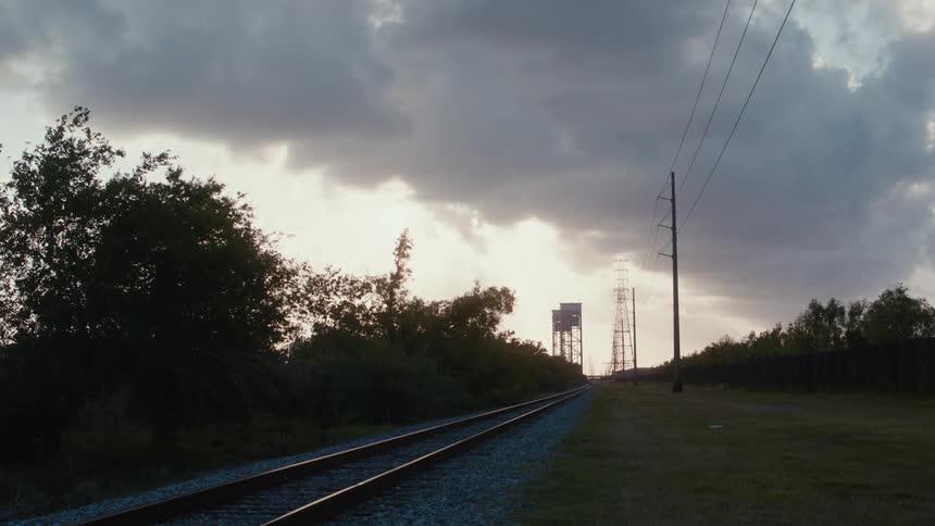 A rural railroad track on a cloudy evening