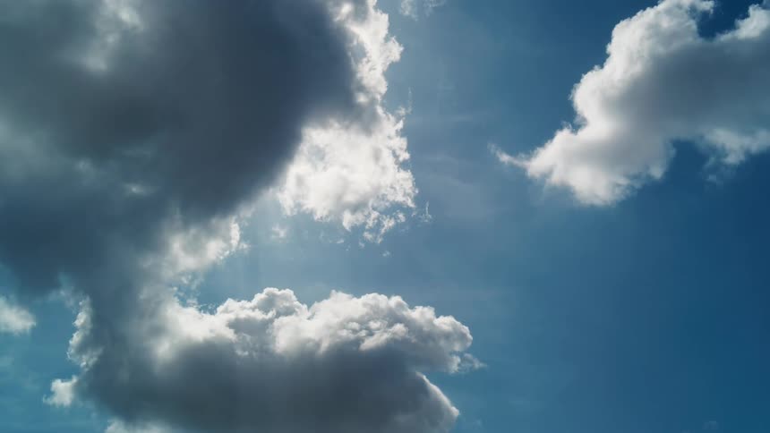 Fluffy clouds slowly passing on a bright blue day
