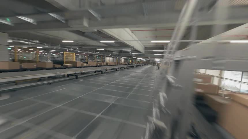 An FPV Drone Races Through a Fully Automated Distribution Warehouse with Boxes on a Production Line