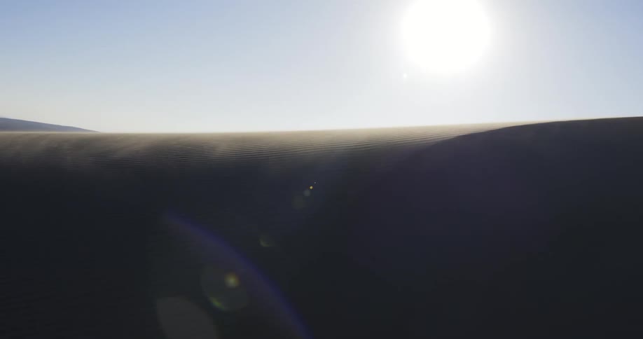 The sun shining down on a sand dune in a desert