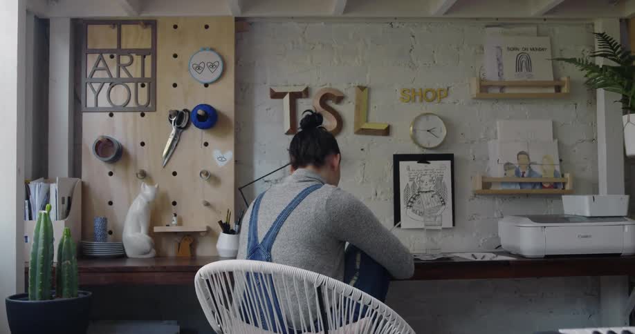 A young female artist is sitting down and painting a picture