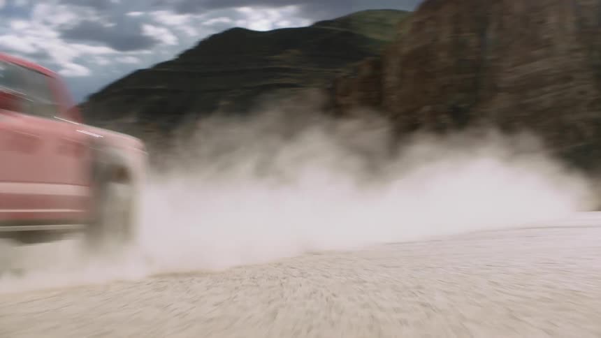 A truck is driving down the street in the desert area