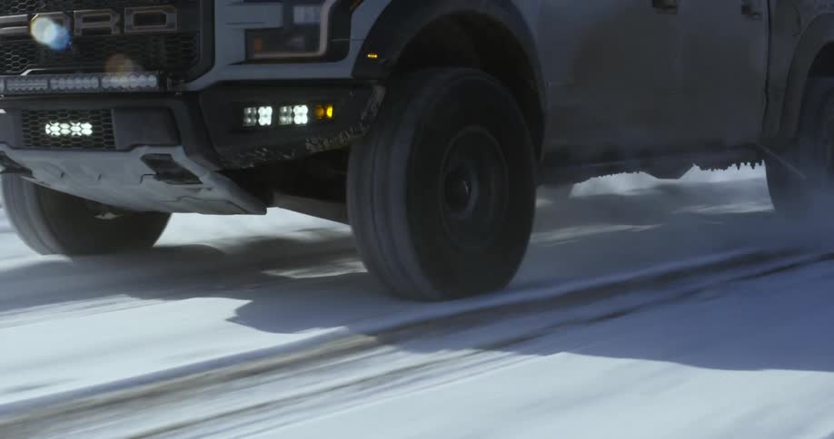 White pickup truck drives on snowy road
