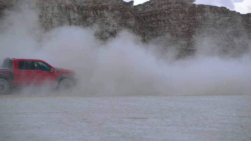 A truck is driving off road in a desert area