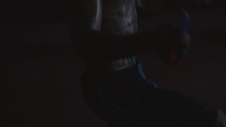A young black man is jump roping inside of a building