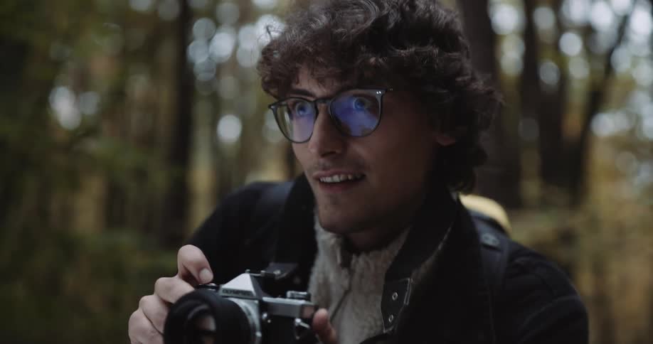 A young white man is taking pictures of the nature in the day time