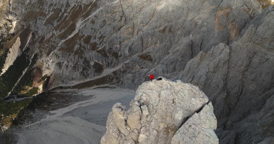 Aerial view of a person climbing up a mountain is displayed