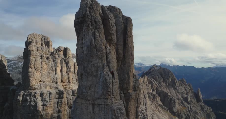 A person is climbing up a rock formation by themselves