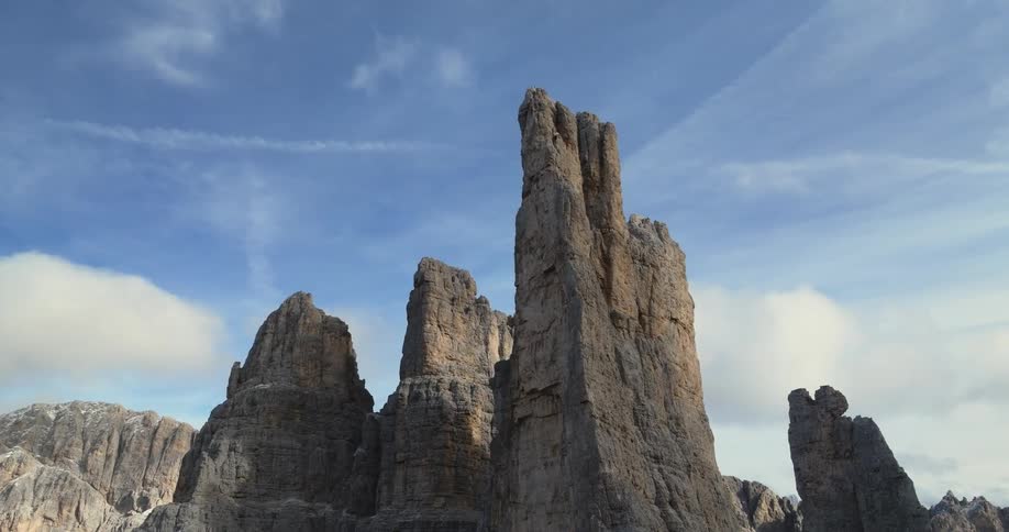 Aerial orbiting view of tall rock towers on a mountain range at morning