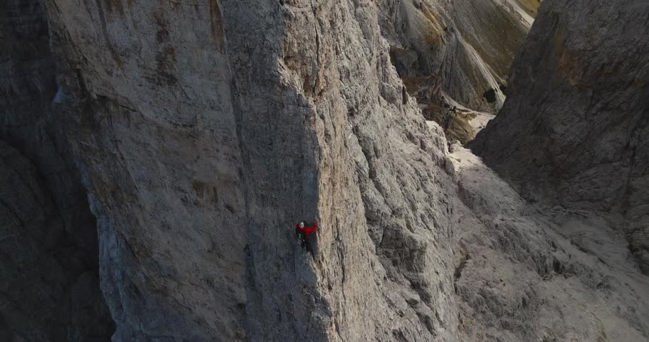 A young man is rocking climbing in the summer time