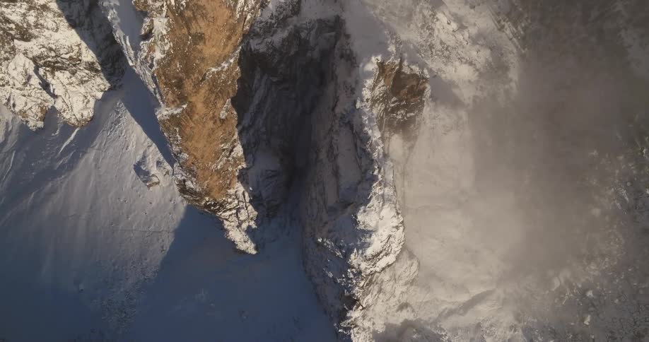 There is a view of a cliff that is covered with snow in the winter