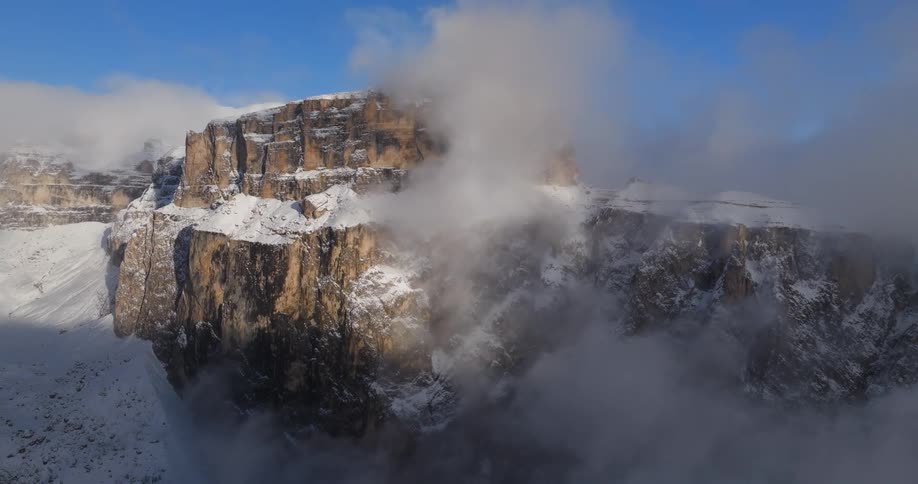 There is a mountain that is covered with snow and its really foggy