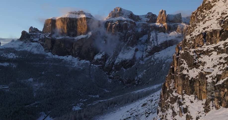 An aerial view of a snowy mountain range in the wilderness on a winter morning