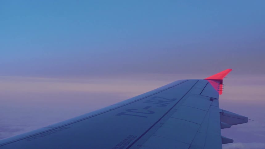 The wing of an airplane and the clouds below it while in flight