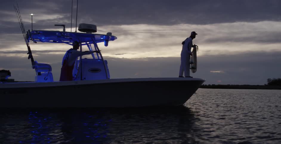 Two men on a rescue mission on a boat looking for someone in the water